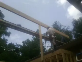 Carpenter setting a ridge beam over a new addition frame — Ice Dam Removal by Roofing Brothers in Lakehurst