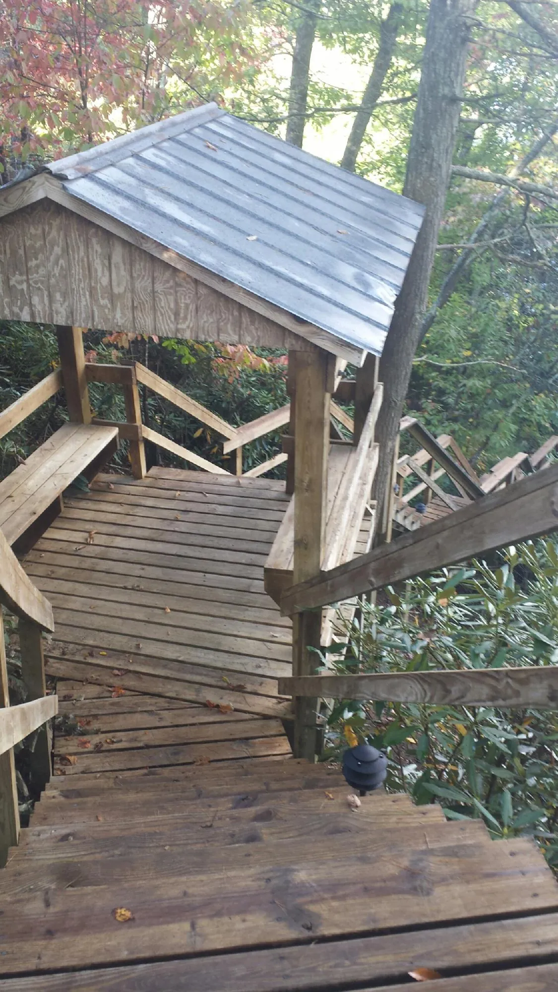 Metal roofed shelter over wooden steps on a wooded walkway — Skylight Repair & Installation work by our crew in Lakehurst